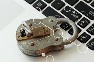 conceito de segurança na internet-empresário em miniatura fica na chave antiga e cadeado no teclado do computador portátil foto