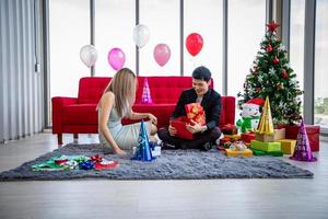 amante de casal asiático está dando uma caixa de presente com presente de natal no feriado de natal e feliz ano novo rissol foto