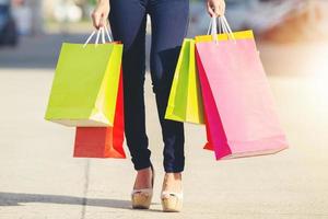 Linda garota asiática segurando sacolas de compras e sorrindo foto