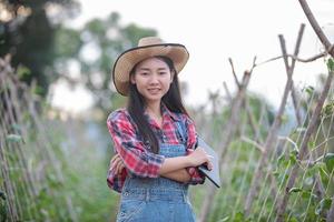 mulheres agrônomas e agricultoras da ásia usando tecnologia para inspecionar em campos agrícolas e vegetais orgânicos foto