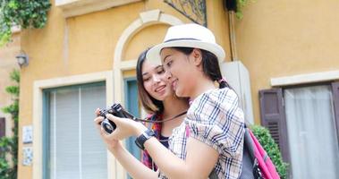 Mochilas de mulheres asiáticas caminhando juntas e felizes estão tirando fotos e olhando fotos, relaxe na viagem do conceito de férias