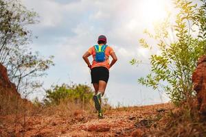 um homem corredor de trilha. e pés de atleta usando sapatos esportivos para trilha nas montanhas foto