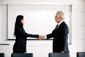 empresários apertando as mãos e sorrindo concordando em assinar contrato e encerrar uma reunião