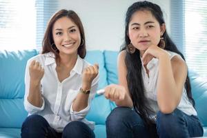 retrato de estilo de vida mulheres asiáticas de melhores amigos - sorrindo feliz no sofá na sala de estar foto