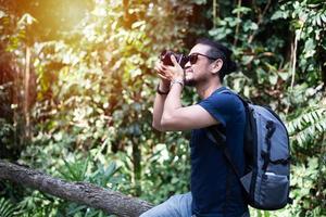 mochilas de homens asiáticos e viajantes caminhando juntos e felizes estão tirando fotos na montanha, relaxe o tempo em viagens de conceito de férias