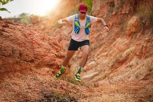 um homem corredor de trilha. e pés de atleta usando sapatos esportivos para trilha nas montanhas foto