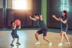 família asiática jogando basquete juntos. família feliz passando tempo livre junta nas férias foto