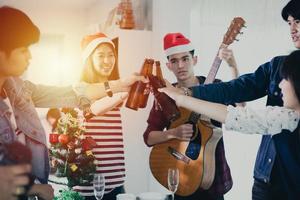 grupo asiático de amigos festejando com bebidas alcoólicas de cerveja e jovens desfrutando em um bar brindando coquetéis foto