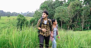 Grupo asiático de jovens caminhando com mochilas de amigos caminhando juntos e olhando o mapa e tirando a câmera fotográfica na estrada e parecendo feliz, relaxe o tempo na viagem do conceito de férias foto