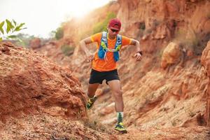 um homem corredor de trilha. e pés de atleta usando sapatos esportivos para trilha nas montanhas foto