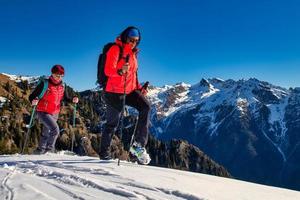 par de mulheres praticam montanhismo na neve foto