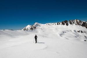mulher solteira praticando alpinismo de esqui nos Alpes foto