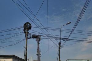 emaranhado de cabos elétricos e telefônicos entre postes em cidades da américa do sul foto