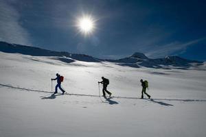 corda de três alpinistas de esqui em uma pista de escalada foto