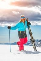 garota freeride esquiadora, alegre sorrindo antes da descida da montanha foto