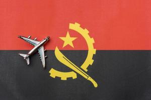 o avião sobre a bandeira de angola, o conceito de viagem. foto