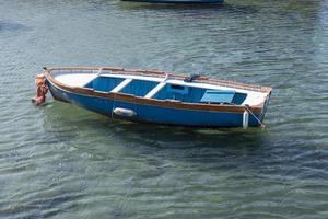 velho barco de madeira no cais em águas claras. foto