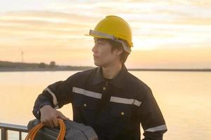 um engenheiro masculino usando um capacete protetor ao pôr do sol. foto