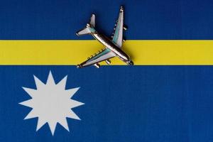 avião de brinquedo sobre a bandeira de nauru, conceito de viagens. foto