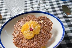 deliciosa sobremesa com um biscoito fino e uma fatia de laranja. pronto para comer foto