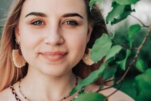 retrato de uma linda loira com beleza natural em um verde deixa árvores. copiar, espaço vazio para texto foto