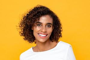 retrato simples de perto de uma mulher afro-americana atraente sorridente em fundo amarelo de estúdio isolado foto