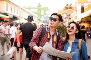 turistas de casal asiático viajando na estrada khao san bangkok tailândia durante as férias de verão foto