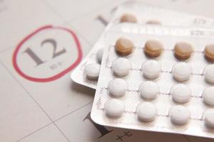pílulas anticoncepcionais, calendário na mesa close-up foto