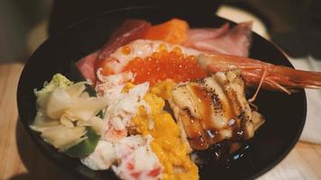 Feche imagens de tigela de arroz de frutos do mar japonês ou kaisendon sashimi donburi. foto