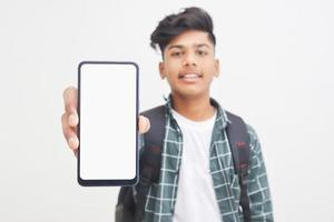jovem estudante universitário indiano mostrando a tela do smartphone em fundo branco. foto
