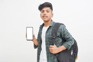 jovem estudante universitário indiano mostrando a tela do smartphone em fundo branco. foto