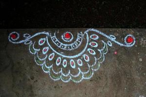 rangoli é a arte de desenhar desenhos usando pó de pedra e decorado com cores e flores foto