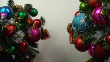conceito de temporada de saudação configuração manual de enfeites em uma árvore de natal com luz decorativa foto