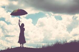 silhueta de mulher segurando guarda-chuva dia ensolarado foto