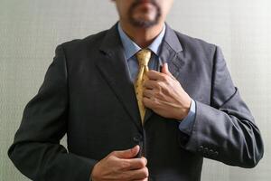 empresário ajustando gravata, vista frontal, sem cabeça. conceito de trabalhar em um escritório. foto