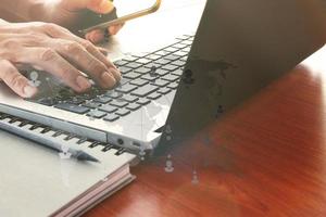 close-up da mão de homem de negócios trabalhando no computador portátil na mesa de madeira como conceito foto