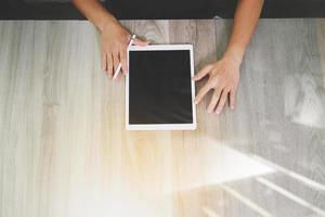 vista superior da mão do designer trabalhando com computador tablet digital na mesa de madeira como conceito de design web responsivo foto