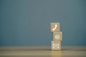 cubo de bloco de madeira closeup com e-mail de símbolo, endereço, telefone na mesa de madeira foto