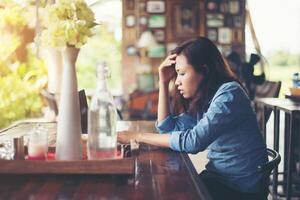 jovem sentada em um café com seu laptop, estressante para o trabalho. foto