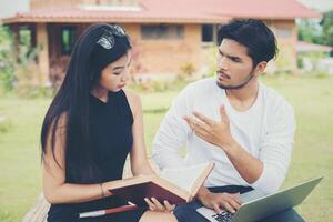 jovem casal de educação sentado no banco ao ar livre e bom tempo. e eles estão felizes, conceito de estilo de vida. foto