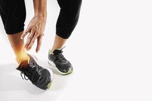 esportista de corredor segurando o tornozelo com dor com lesão de esporte de corrida de articulação torcida quebrada e homem atlético tocando o pé devido a entorse no fundo branco