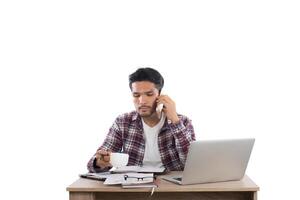 empresário falando ao telefone enquanto trabalha com laptop no escritório isolado no fundo branco. foto