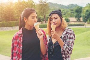 close-up tiro de sorvete na mão de uma mulher em pé com sua amiga. férias de verão juntos. foto