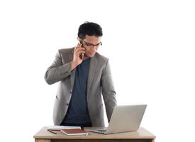 empresário trabalhando no laptop e ligando no telefone, fundo branco. foto