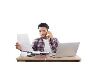 empresário falando ao telefone enquanto trabalha com laptop no escritório isolado no fundo branco. foto