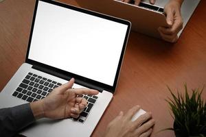 vista superior da mão do empresário trabalhando com o novo laptop de computador moderno com tela em branco e livro em branco como conceito foto