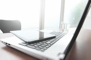 computador portátil na mesa de escritório com caneta e tablet digital como conceito de negócio de espaço de trabalho foto