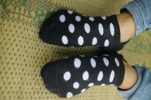 pés usando meias pretas com bolinhas brancas foto