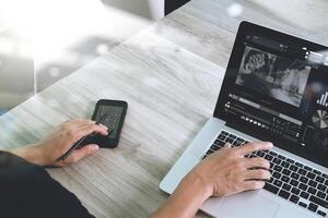 mão de designer de site participando de videoconferência com computador portátil na mesa no escritório foto