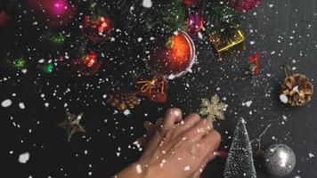 conceito de temporada de saudação configuração manual de enfeites em uma árvore de natal com luz decorativa foto